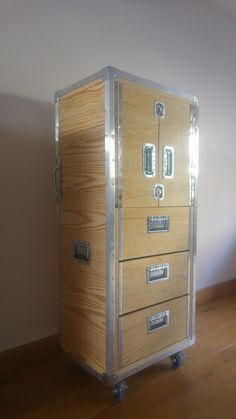 a large wooden box sitting on top of a hard wood floor next to a wall