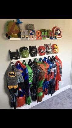 a wall with many different types of batman costumes on it and hanging from the ceiling