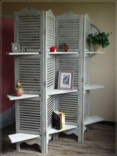 a room divider made out of shutters and bookshelves