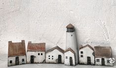 a group of small houses sitting next to each other on top of a white wall