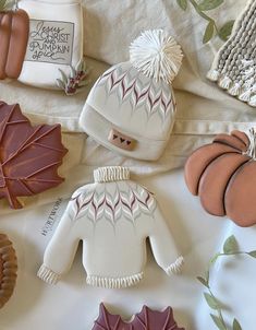 some cookies are laying on a table with hats and scarves around them as well