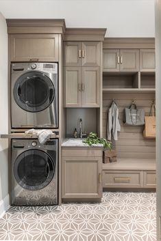 a washer and dryer in a room with wooden cupboards on the wall