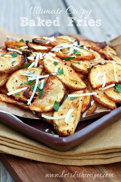 a plate full of potato wedges with parmesan cheese on top