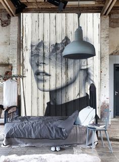 a bedroom with a painting on the wall next to a bed