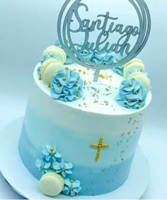 a cake with blue frosting and flowers on the top is decorated with a cross