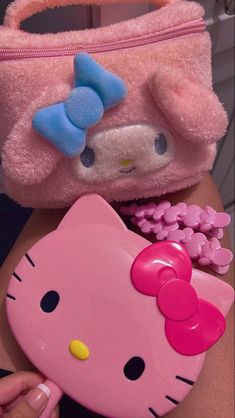 a pink hello kitty purse with a blue bow on it