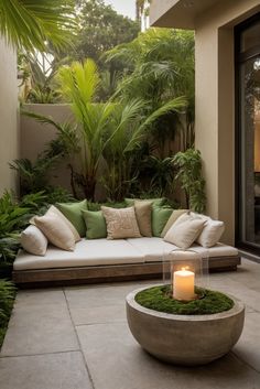 a couch sitting on top of a stone floor next to a lush green plant covered wall