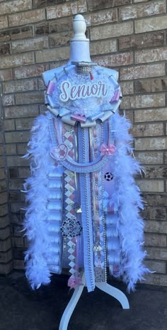 a mannequin is adorned with blue feathers and ribbons that say sequins