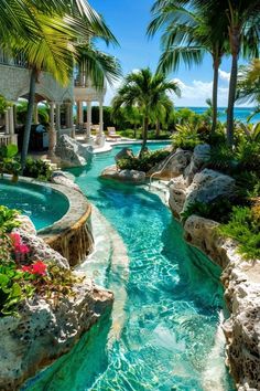 an outdoor swimming pool surrounded by palm trees and water features blue, green, and white colors