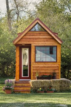 a small wooden cabin sitting on top of a lush green field