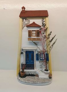 a ceramic house with blue doors and windows