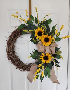 a wreath with sunflowers and greenery on the front door