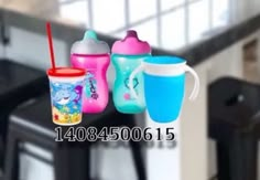 three sippy cups sitting next to each other on top of a kitchen countertop