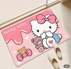 a hello kitty mouse pad sitting on top of a floor next to shoes and a pair of slippers