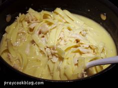 pasta with chicken and sauce in a skillet on the stove, ready to be cooked