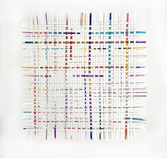 an art piece made out of strips of colored thread on a white surface with a square pattern in the middle