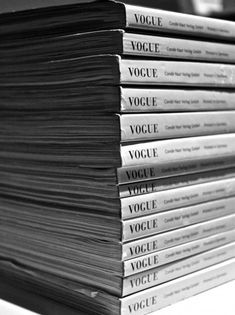 a stack of books sitting on top of a white table next to a black and white photo