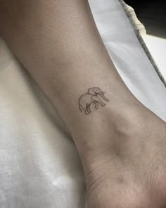 a small elephant tattoo on the left ankle is shown in black ink, and it's outline shows an elephant