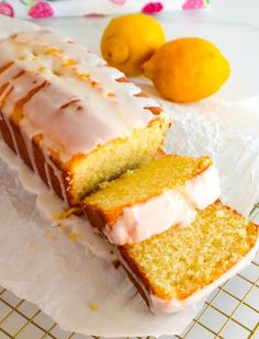 a loaf of lemon pound cake sitting on top of a white plate next to two oranges