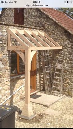 a house being built with a wooden roof and ladders attached to the side of it