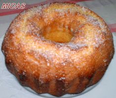 a donut sitting on top of a white plate covered in powdered sugar