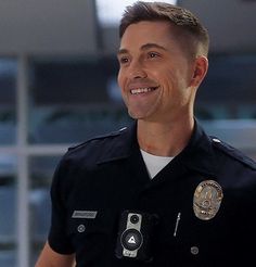 a man wearing a police uniform standing in front of a building