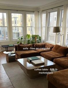 a living room with couches, coffee table, and large windows in it's center