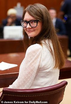 a woman sitting at a table in front of a judge's chair with papers on it