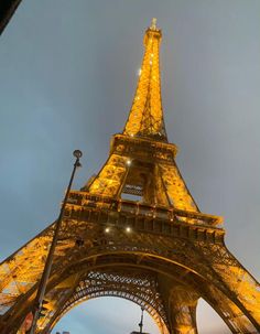 the eiffel tower lit up at night with lights on it's sides