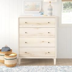 a white dresser sitting next to a window in a room