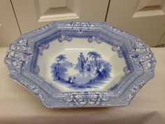 a blue and white plate sitting on top of a table next to a door way