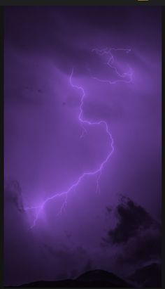 a purple sky with lightning and clouds in the background