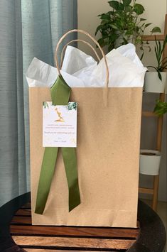 a brown paper bag with a green ribbon