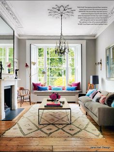 a living room filled with furniture and a fire place in front of a large window