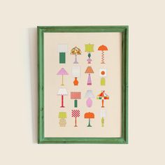 a green frame holds an art print with lamps and lampshades on the wall