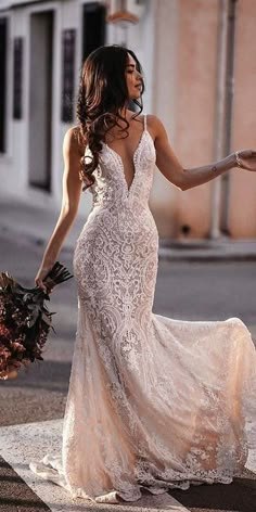 a woman in a wedding dress is walking down the street with her hand on her hip