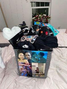 a basket filled with clothes and shoes on top of a bed