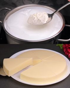 a pan filled with cheese next to a white plate