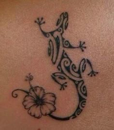 a lizard tattoo on the back of a woman's stomach, with a flower