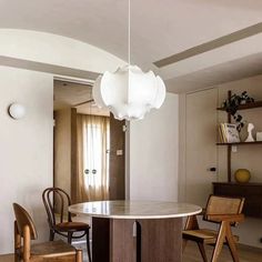 a dining room table with chairs and a light fixture hanging from the ceiling above it