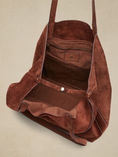 Wider than it is tall, this East-West tote fits most laptops up to 15" and is crafted in soft, sturdy suede with a special zip pocket to keep small items handy.  Open top (no closure).  Two interior slip pockets.  One interior zip pocket.  Unlined. Suede Shoulder Bag With Removable Pouch For Travel, Travel Suede Shoulder Bag With Removable Pouch, Suede Satchel With Zipper Closure, Suede Bags With Zipper Closure For Daily Use, Suede Shoulder Bag With Zipper For Daily Use, Daily Use Suede Shoulder Bag With Zipper Closure, Daily Use Suede Shoulder Bag With Zipper, Daily Use Suede Bag With Zipper Closure, Brown Suede Bag With Zipper Closure