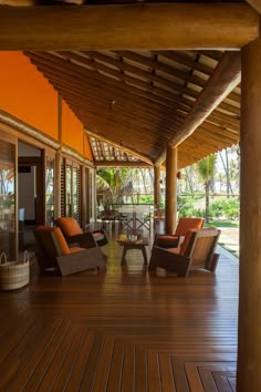 an outdoor area with chairs and tables on the wooden floor, along with palm trees