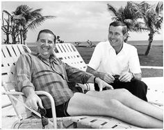 two men sitting next to each other on beach chairs