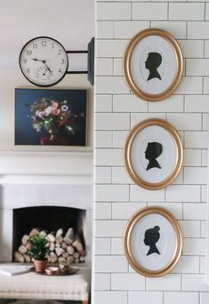 three framed silhouettes hang on the wall next to a fireplace with a clock above them