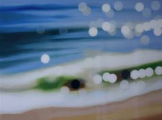 blurry photograph of the ocean and beach with white circles on it's surface