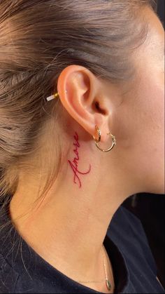 a woman with a small tattoo behind her ear