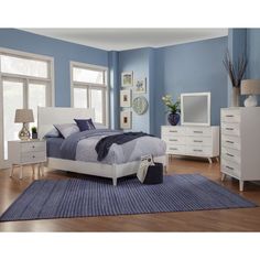 a bedroom with blue walls and white furniture