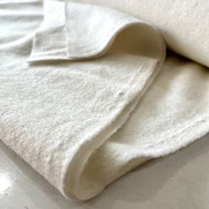 a white blanket folded on top of a table