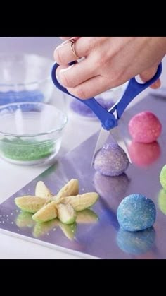 a person is using scissors to cut colored candies