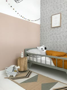 a small child's bed in a room with pink walls and white flooring